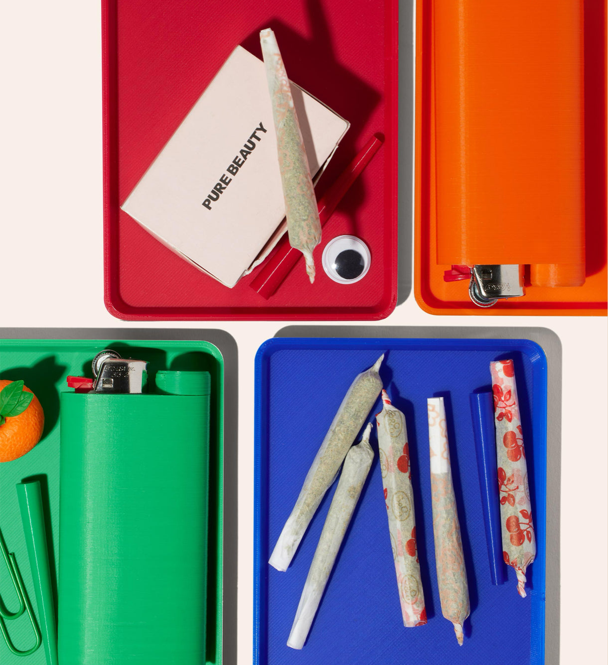 Rolling trays in Strawberry Red, Safety Orange, Kelly Green, and Internet Blue, with joint cone, rolling papers, joints, and Jointlockers
