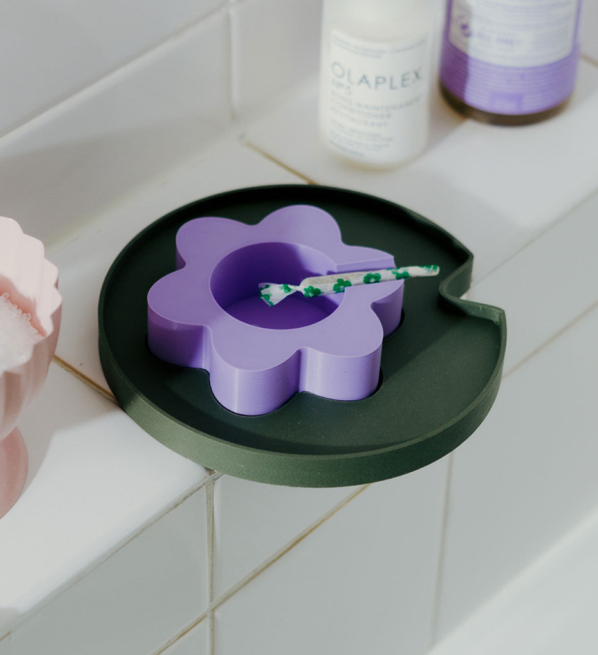 The 3D printed Floating Lilac Flower Ashtray sitting on the side of a bathtub with a joint