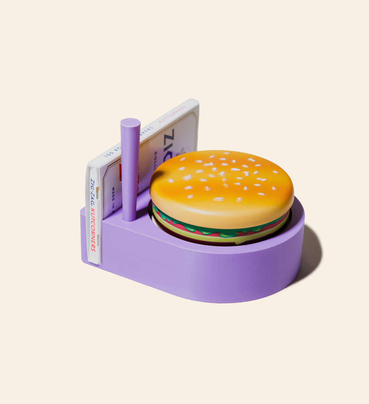 The purple Storage Solution with a matching Joint Cone, our beloved Hamburger Grinder, and a pack of standard Zig Zag rolling papers.