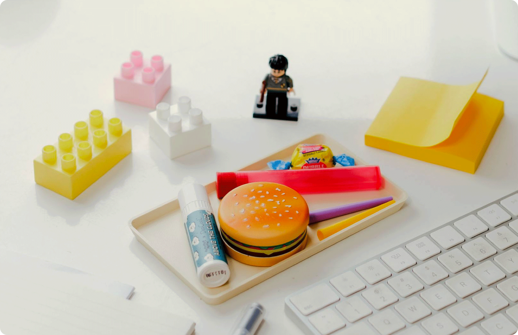 WFH Set Up — The Basic Tray, The Hamburger Grinder, DedCool Chapstick, Joint Cones, Doob Tubes, Muji pen, stickies, Double Bubble, and yes, a mini LEGO Harry Potter.